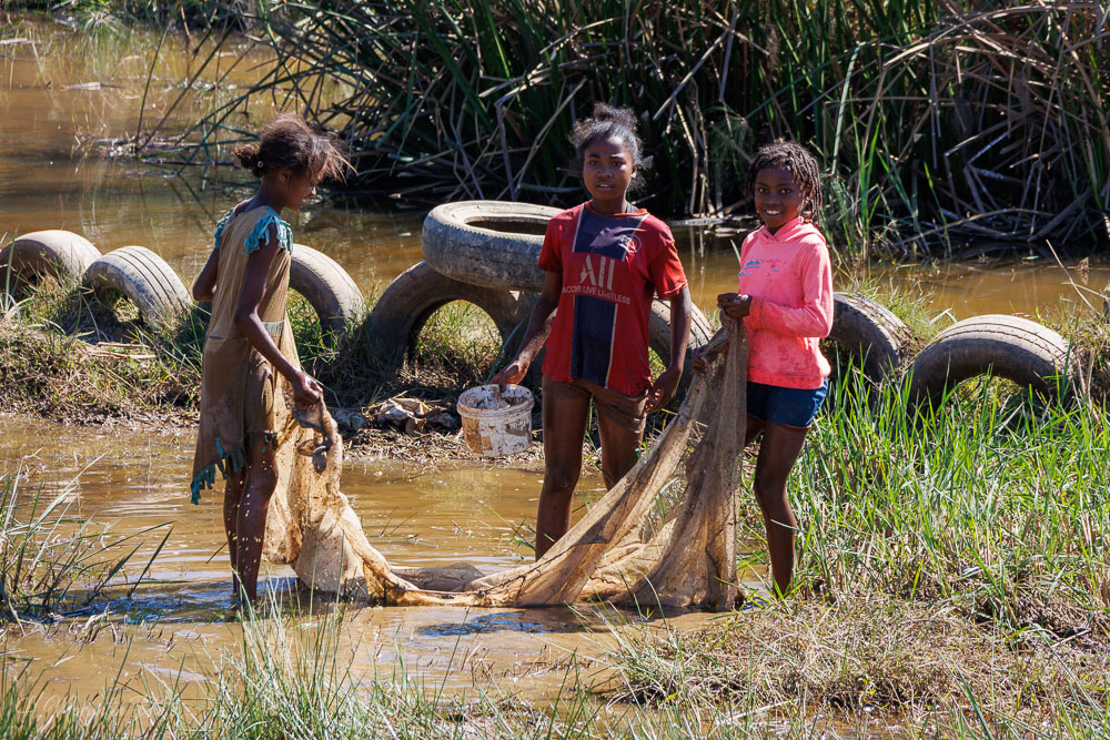 Enfants pêchant au filet dans la rivière