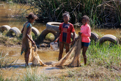 Enfants pêchant au filet dans la rivière